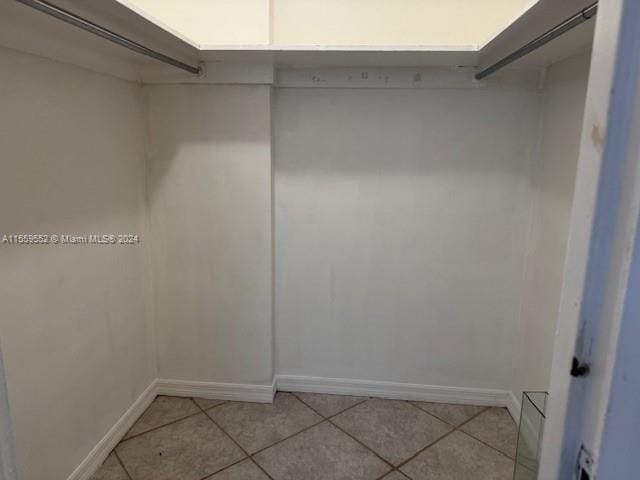 walk in closet with light tile flooring