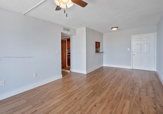 empty room with a textured ceiling, hardwood / wood-style floors, and ceiling fan