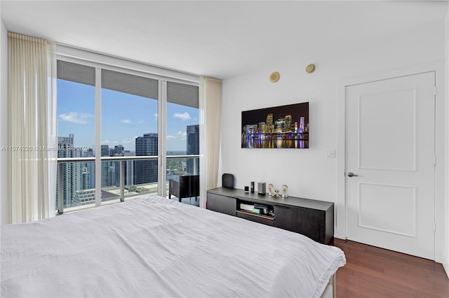 bedroom with floor to ceiling windows, access to exterior, and dark hardwood / wood-style floors