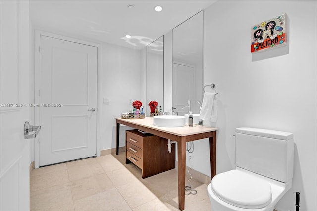 bathroom with a shower, toilet, tile flooring, and large vanity