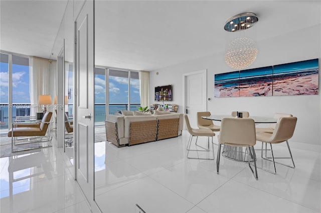 tiled dining area featuring a wall of windows, a water view, and a wealth of natural light