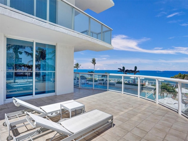 view of patio with a balcony and a water view