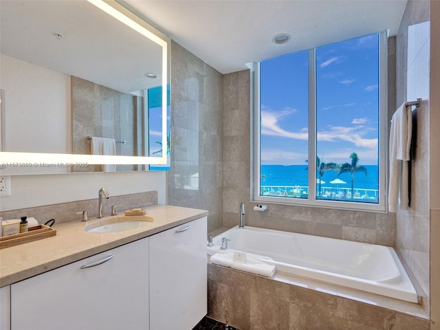 bathroom with vanity and tiled bath