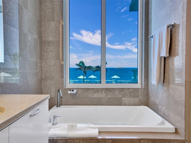 bathroom with vanity and tiled tub