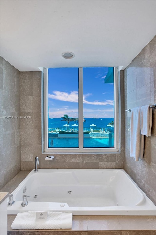 bathroom with plenty of natural light and a relaxing tiled tub