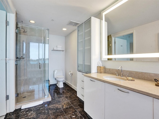 bathroom with vanity, toilet, and a shower with door