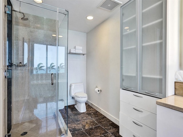 bathroom featuring vanity, an enclosed shower, and toilet