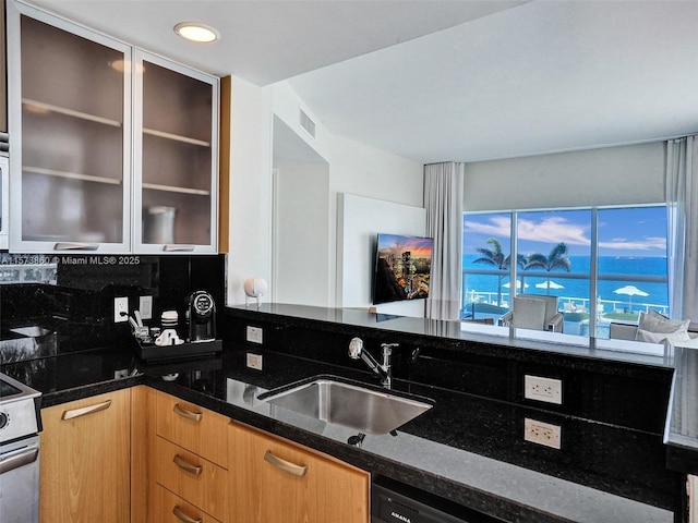 kitchen with dark stone countertops, sink, stainless steel electric range, and tasteful backsplash