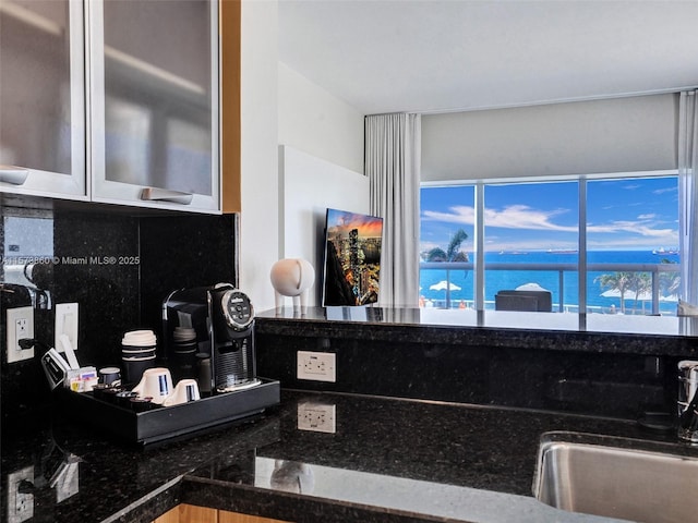 kitchen featuring a water view, sink, a wealth of natural light, and decorative backsplash