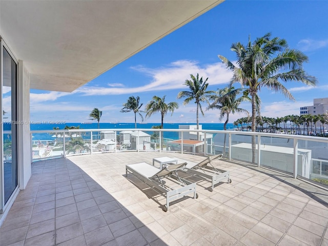 view of patio / terrace with a balcony and a water view