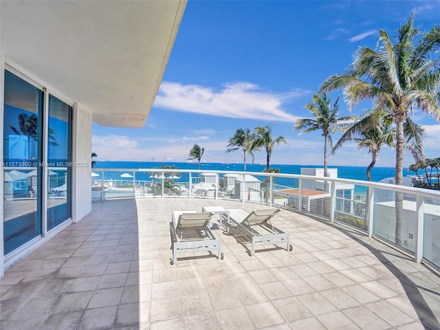 view of patio with a balcony and a water view