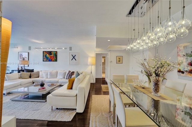 living room featuring an inviting chandelier and dark wood-type flooring