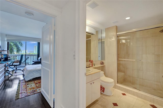 bathroom featuring hardwood / wood-style flooring, a shower with door, toilet, and large vanity