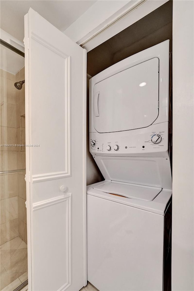 clothes washing area with stacked washing maching and dryer