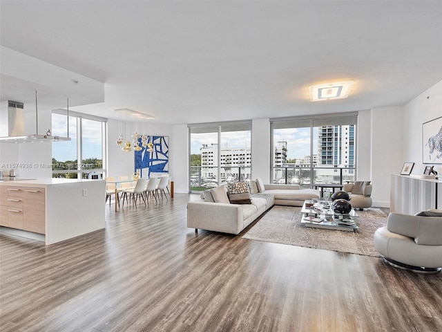 living room with floor to ceiling windows, hardwood / wood-style floors, and an inviting chandelier