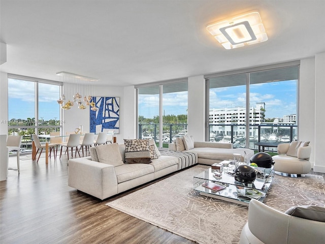 living room featuring a notable chandelier, expansive windows, and wood-type flooring