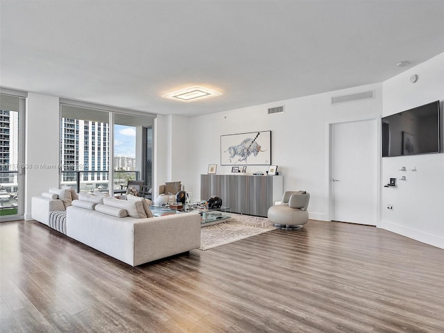 living room featuring wood-type flooring and a wall of windows