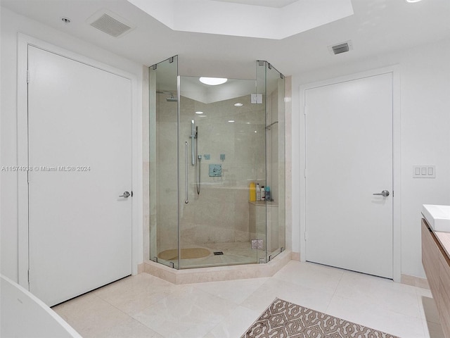 bathroom with walk in shower, vanity, and tile patterned flooring