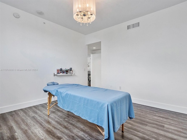 bedroom with a notable chandelier and hardwood / wood-style flooring