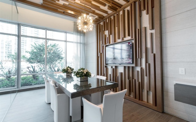 dining room featuring wood-type flooring, a chandelier, and a healthy amount of sunlight