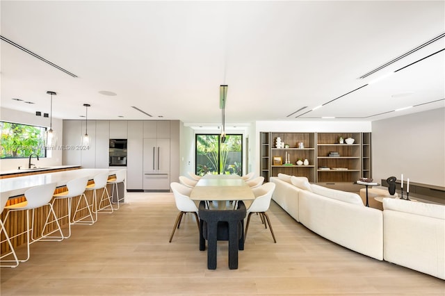 dining area featuring a healthy amount of sunlight, light hardwood / wood-style floors, and sink