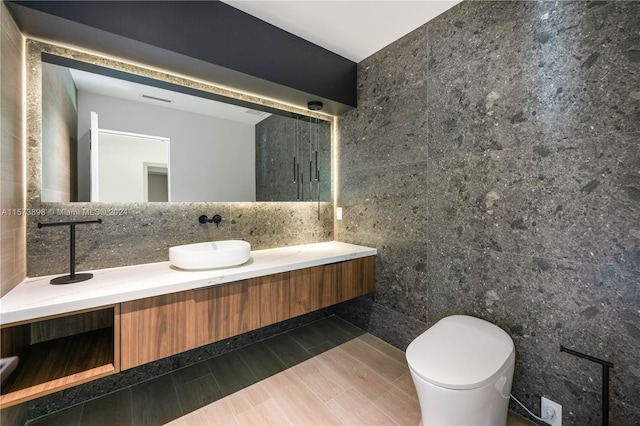 bathroom featuring tile walls, vanity, and toilet