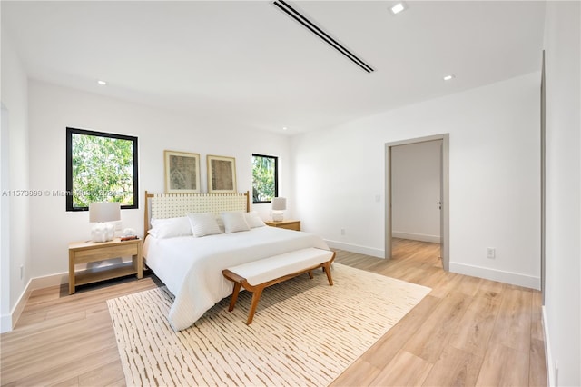 bedroom with multiple windows and light wood-type flooring