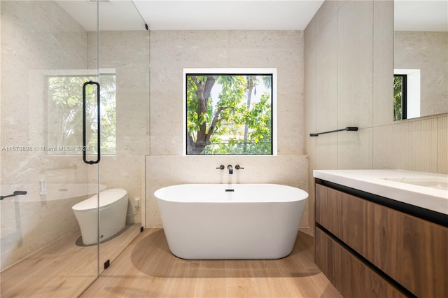 bathroom featuring a shower, vanity, and tile walls