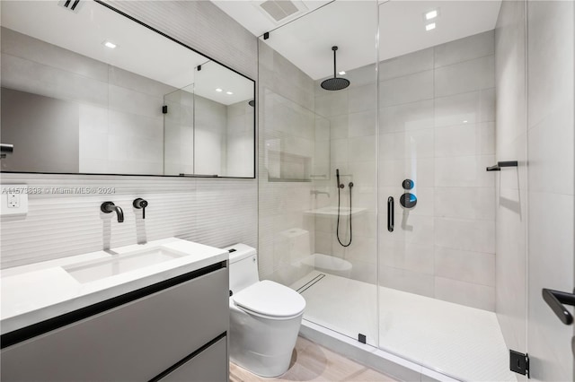 bathroom featuring toilet, tile walls, an enclosed shower, and large vanity