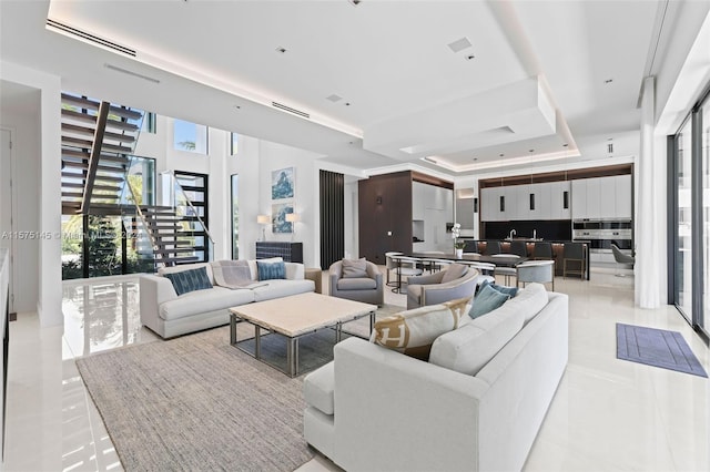 tiled living room featuring a fireplace and a tray ceiling