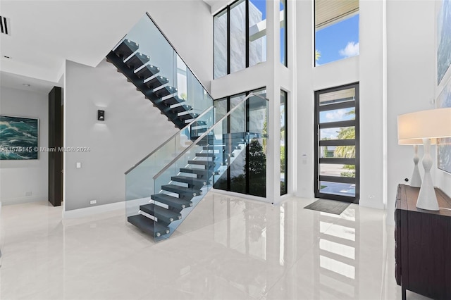 foyer entrance featuring tile flooring and a high ceiling