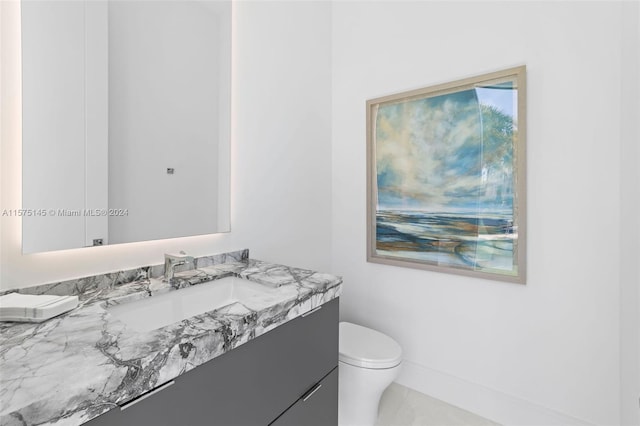 bathroom featuring vanity, tile floors, and toilet