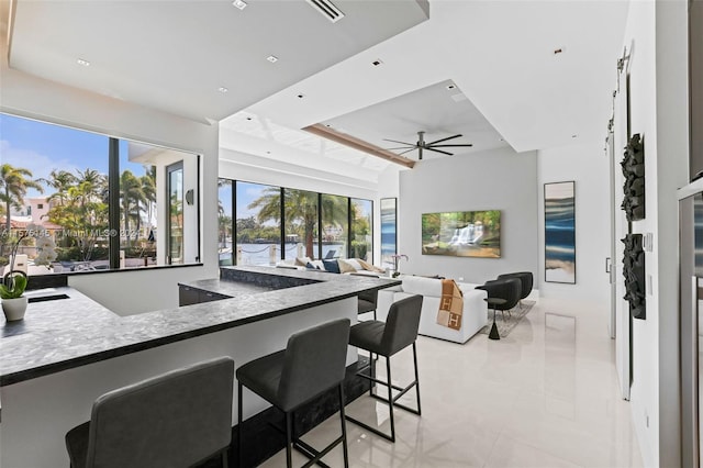 kitchen featuring ceiling fan, a healthy amount of sunlight, and a kitchen breakfast bar