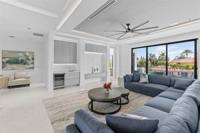 tiled living room featuring sink, ceiling fan, a raised ceiling, and beverage cooler