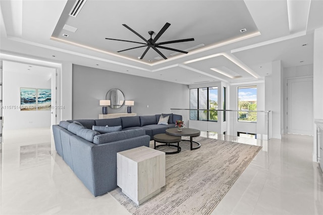 tiled living room featuring ceiling fan and a raised ceiling