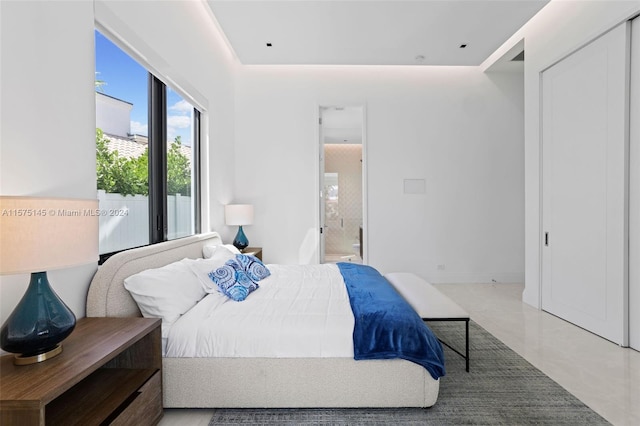 bedroom with ensuite bath and tile floors