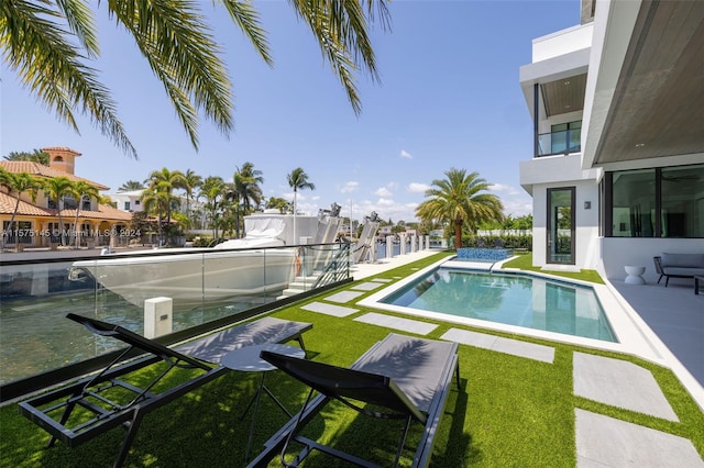 view of swimming pool with a lawn