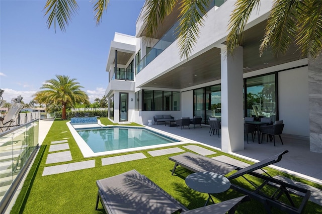 view of pool with a patio and a yard