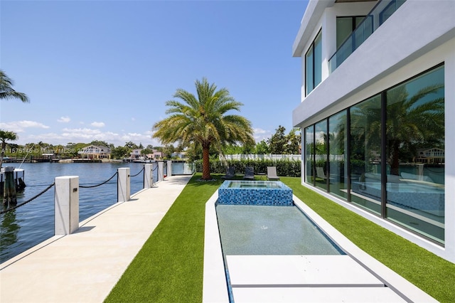 exterior space featuring a dock, a lawn, a swimming pool, and a water view