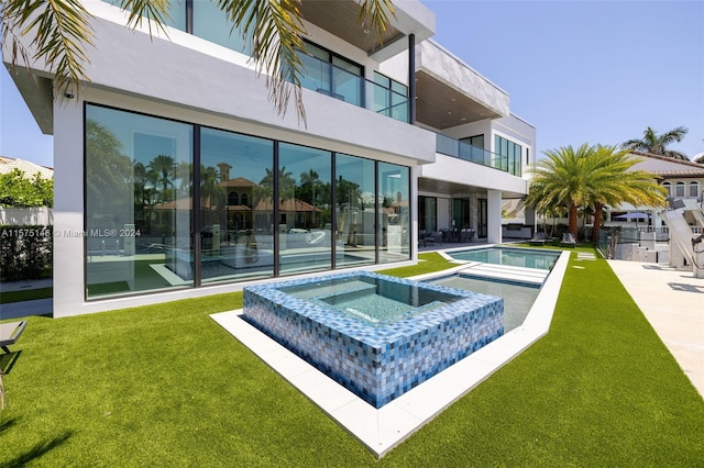 view of swimming pool featuring a yard and an in ground hot tub