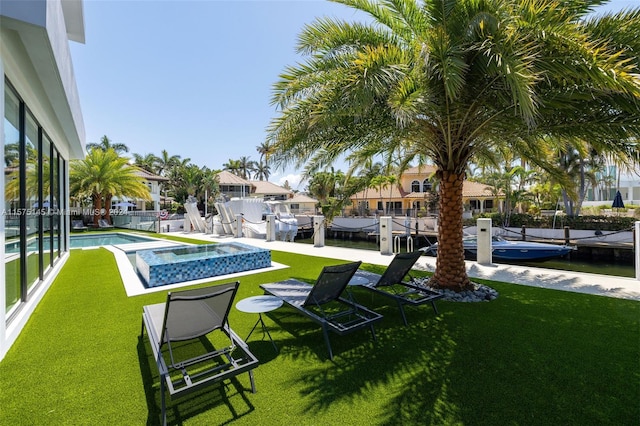 view of yard featuring a fenced in pool and a boat dock