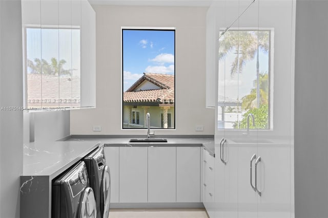 kitchen with sink, a healthy amount of sunlight, and washer and clothes dryer