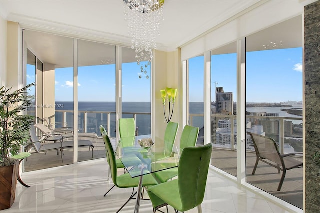 sunroom / solarium featuring a notable chandelier and a water view