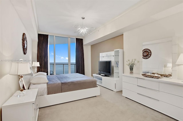 bedroom featuring light colored carpet, a water view, access to exterior, a notable chandelier, and ornamental molding