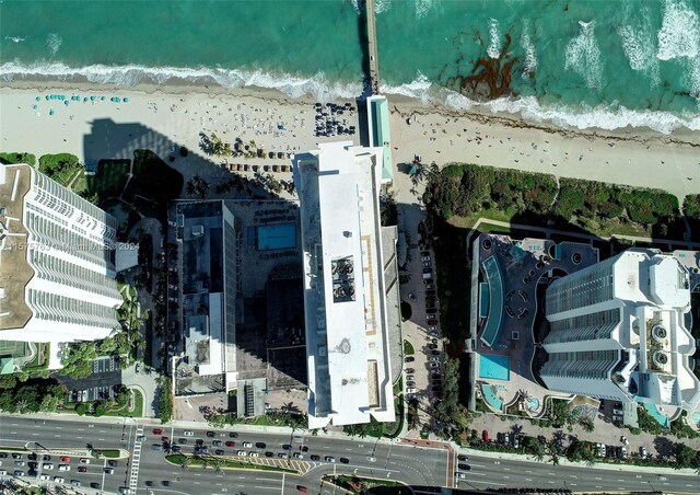 birds eye view of property featuring a beach view and a water view