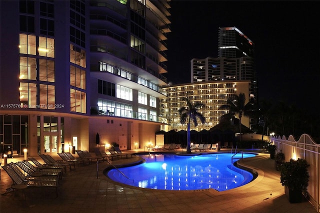 pool at twilight with a patio area