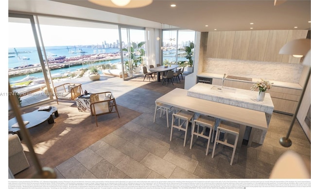 interior space with floor to ceiling windows, dark tile flooring, and a water view