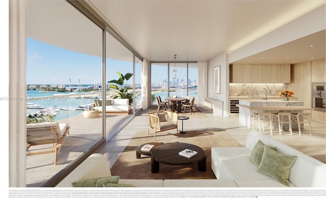 living room with a chandelier, wine cooler, a wall of windows, and a water view