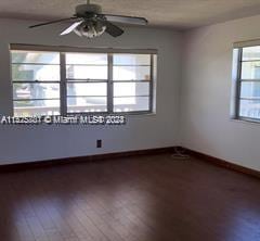 unfurnished room with ceiling fan and dark hardwood / wood-style floors