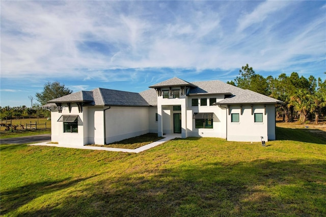 rear view of house featuring a yard